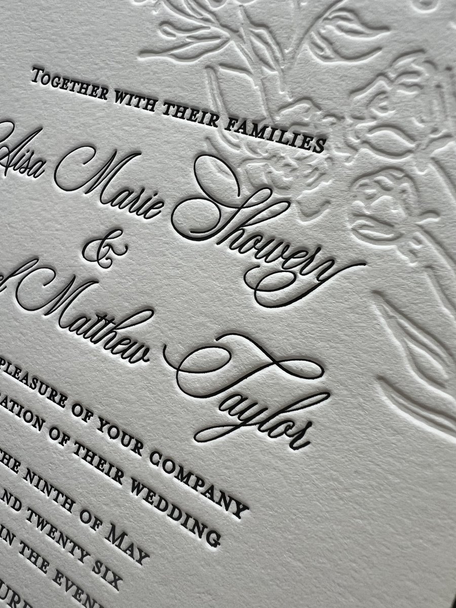 Black letterpress script over a blind debossed floral background on cotton paper